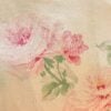 Close-up of the vintage Ralph Lauren Therese floral pattern showing pink and white peonies and roses with green leaves on a sand-colored cotton background