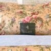 Side view of Ralph Lauren Adriana Floral king pillowcases with pillows inserted and Ralph Lauren placard in front.