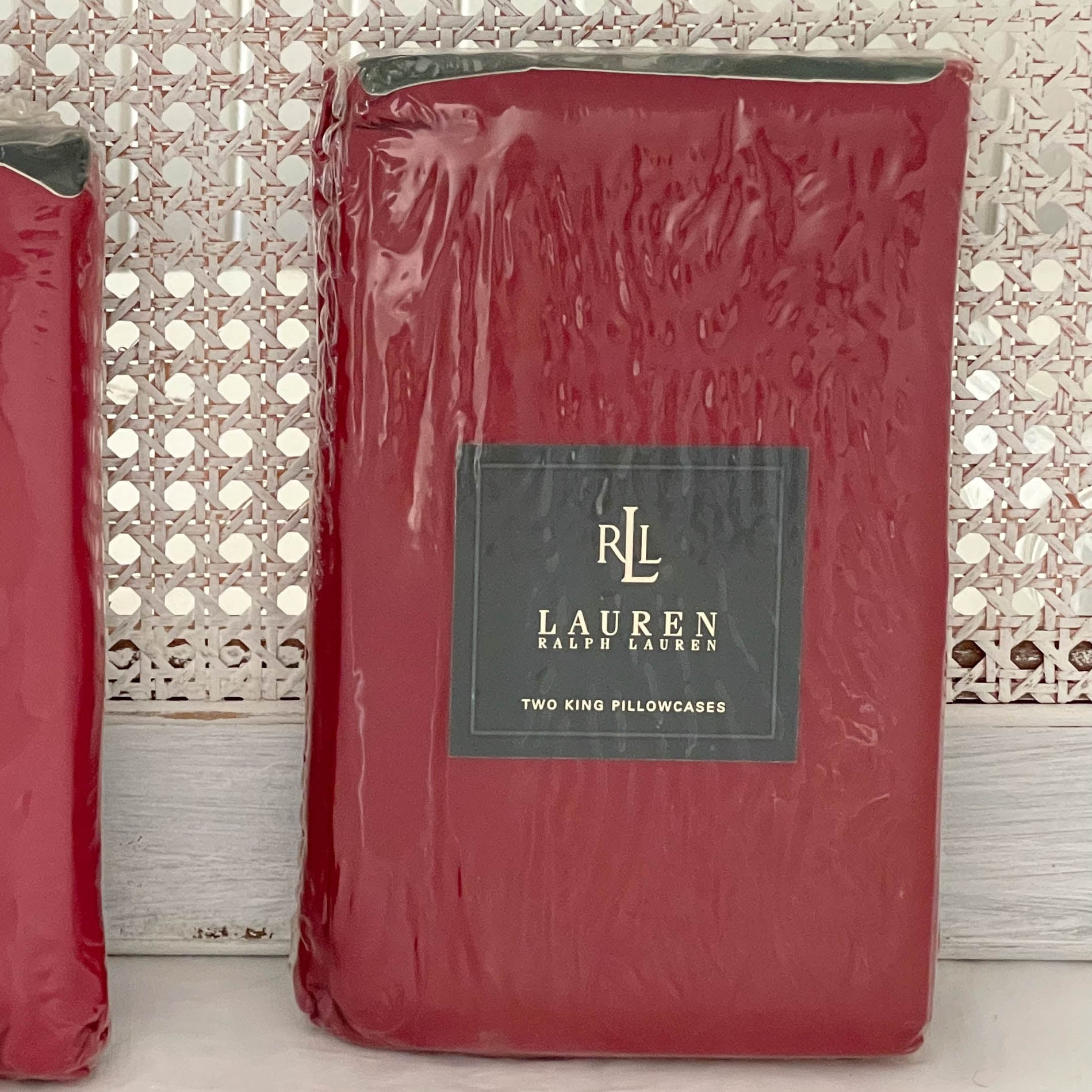 Side shot of Ralph Lauren Lauren’s Solid barn red king pillowcases in original packaging with the Ralph Lauren placard visible.