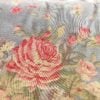 Close-up of Ralph Lauren Shelter Island Blue queen comforter showing pink peonies and wildflowers on a soft sky-blue background.