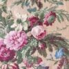 Close-up of Ralph Lauren Adriana Floral flat sheet showing pink peonies, roses, cornflowers, and greenery on a light taupe background.