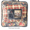 Side view of the Ralph Lauren Cape Cod queen comforter set in its original plastic with the retail placard visible, showing the floral comforter (peonies and wildflowers on navy) and the reversible madras plaid backing.