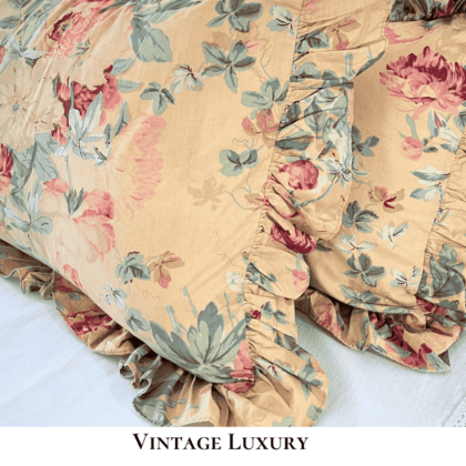 Side view close-up of the Ralph Lauren Elsa Grassland ruffled shams with pillow inserts inside, showing the gold background with pink and red peonies, soft greenery, and the gathered ruffle edge.