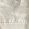 Top-down close-up of the off-white flat sheet header showing the subtle floral jacquard pattern on the Polo Ralph Lauren Estate Collection king sheet.