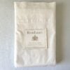 Top-down photo of a neatly folded Polo Ralph Lauren Estate king flat sheet with the white collection placard resting on top.