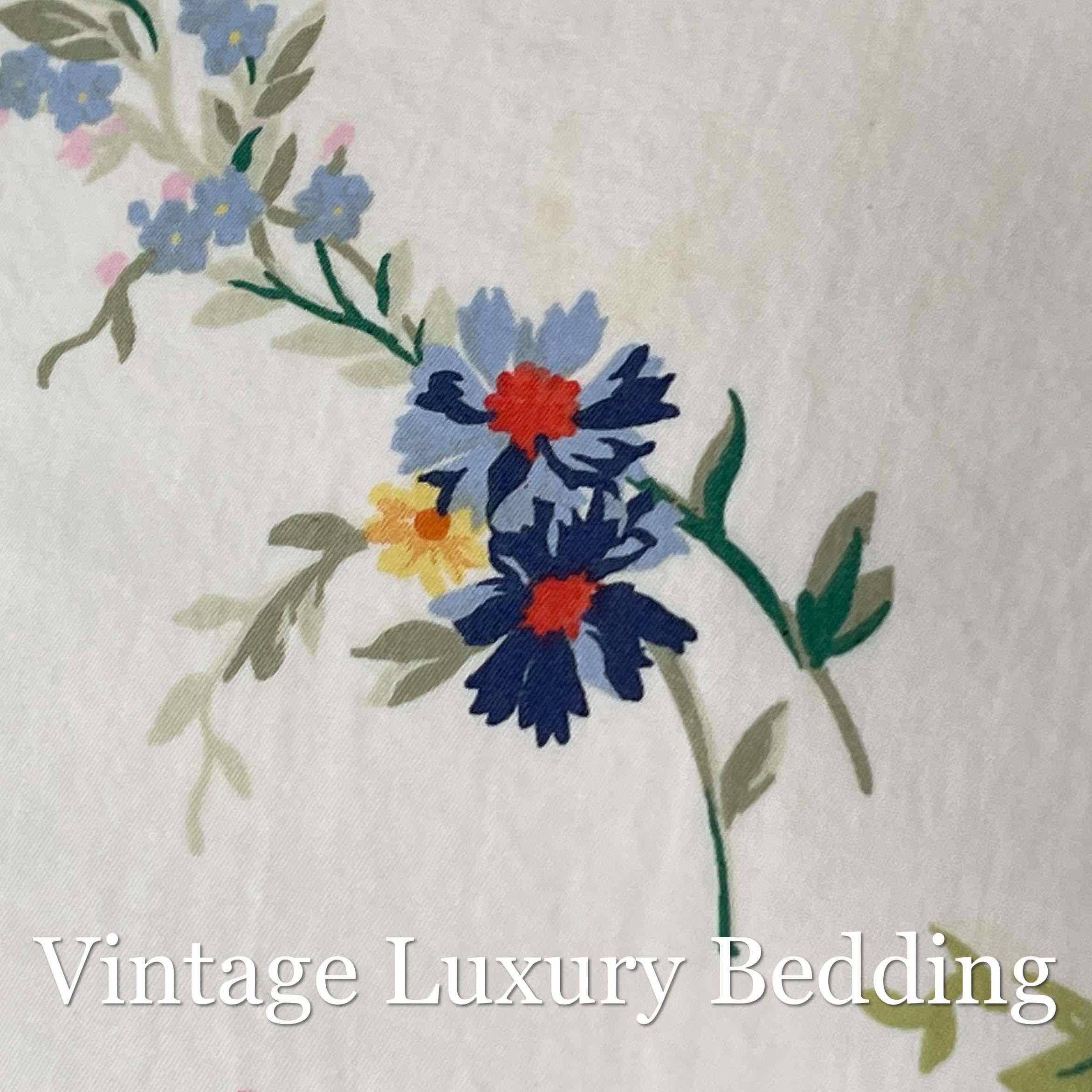 Close-up of the Ralph Lauren Belle Harbor floral pattern featuring blue wildflowers among pink and red peonies on a soft white background.