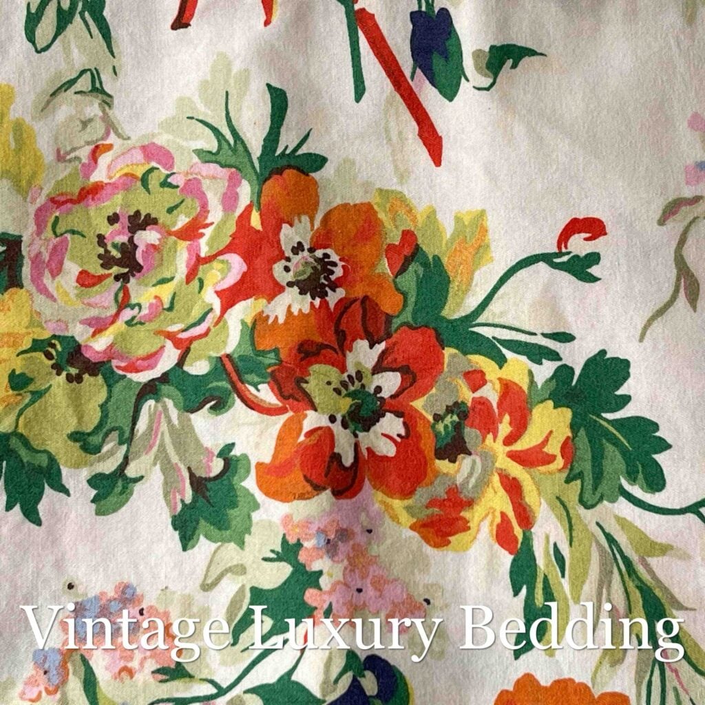 Top-down close-up of the Ralph Lauren Belle Harbor floral pattern with pink and red peonies and multicolor wildflowers on a soft white background.