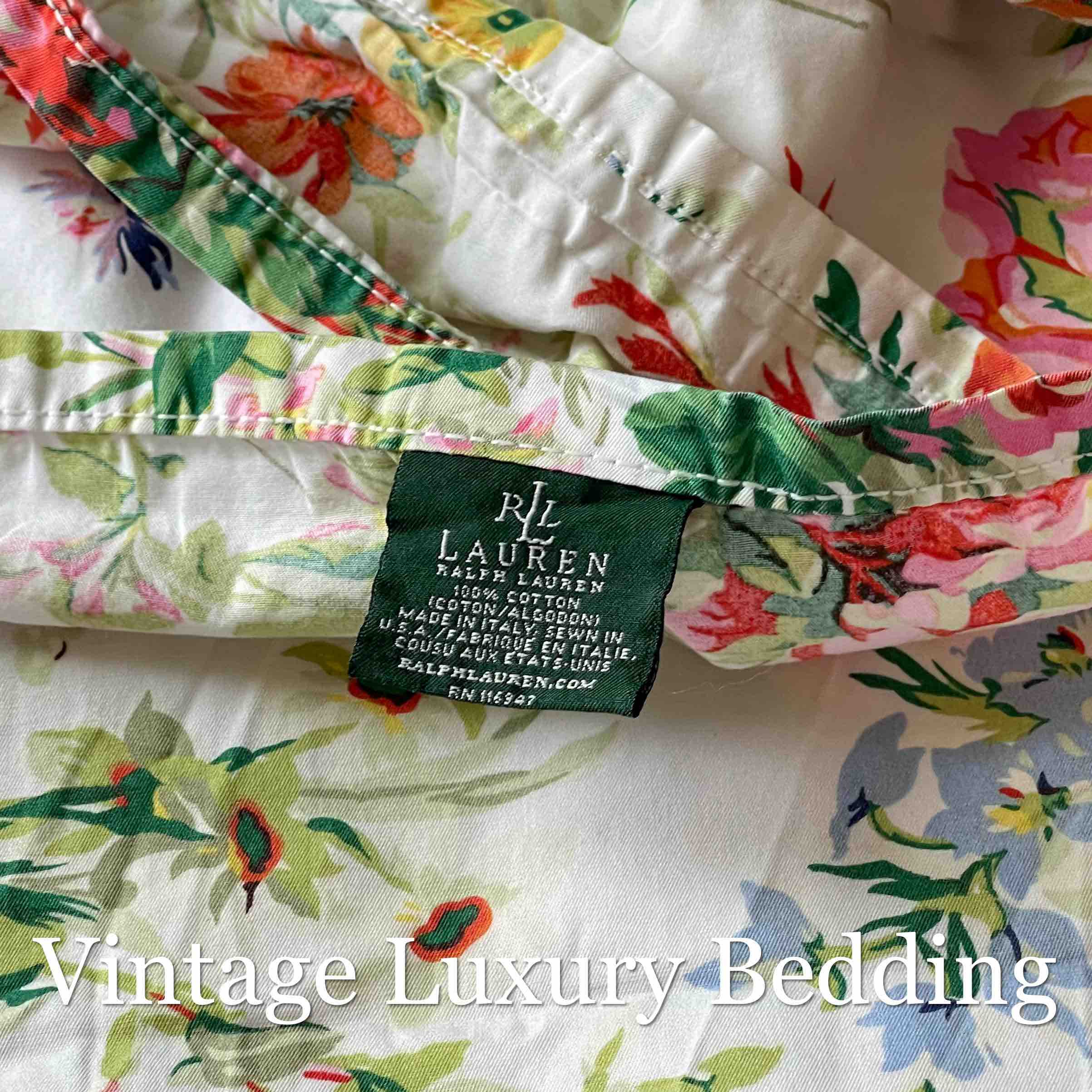 Top-down close-up of the Ralph Lauren tag on the Belle Harbor king flat sheet, showing the floral print with pink and red peonies and multicolor wildflowers.