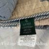 Close-up side shot of the navy Ralph Lauren tag attached to the Chadwick Blue Patchwork Quilt