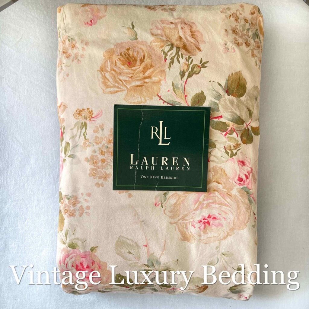 Top-down view of the neatly folded Ralph Lauren Woodstock California king fitted sheet with the Ralph Lauren placard on top.