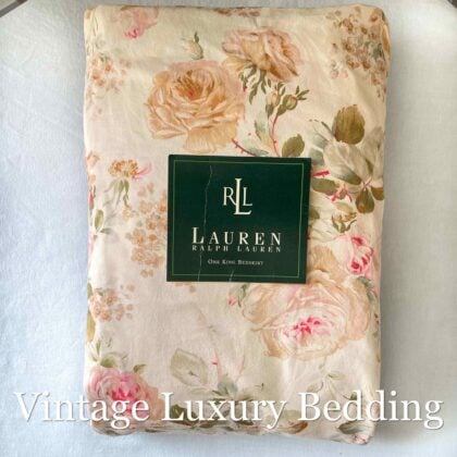 Top-down view of the neatly folded Ralph Lauren Woodstock California king fitted sheet with the Ralph Lauren placard on top.