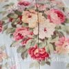 Top-down close-up of the rare retired Ralph Lauren Stone Harbor king comforter showing pink, white, and pale yellow peonies with light blue, lavender, and white wildflowers and soft greenery on a pale aqua background.
