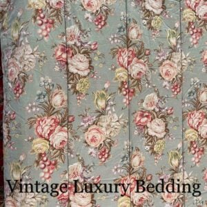 Medium top-down shot of the rare retired Ralph Lauren Charlotte comforter from the Ralph Lauren Home line, showing the repeating floral pattern and the top stitching on the sage green background.
