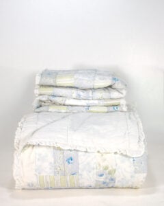 Simply Shabby Chic British Rose Patchwork king quilt and matching ruffled shams folded and stacked front view