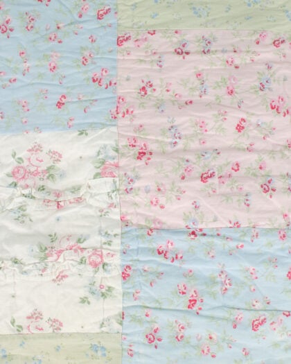 Close-up of Simply Shabby Chic patchwork top-stitched reversible quilt showing quilted floral squares and rectangles