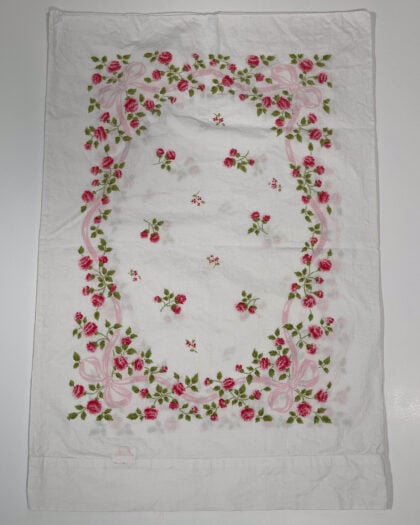 Full top-down view of vintage Springmaid Muslin pillowcase with red wildflowers and pink ribbon detail