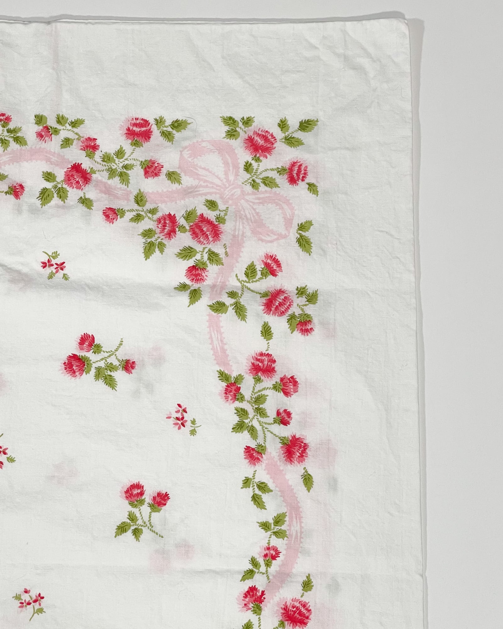 Close-up of red wildflower print and green foliage on vintage Springmaid Muslin pillowcase