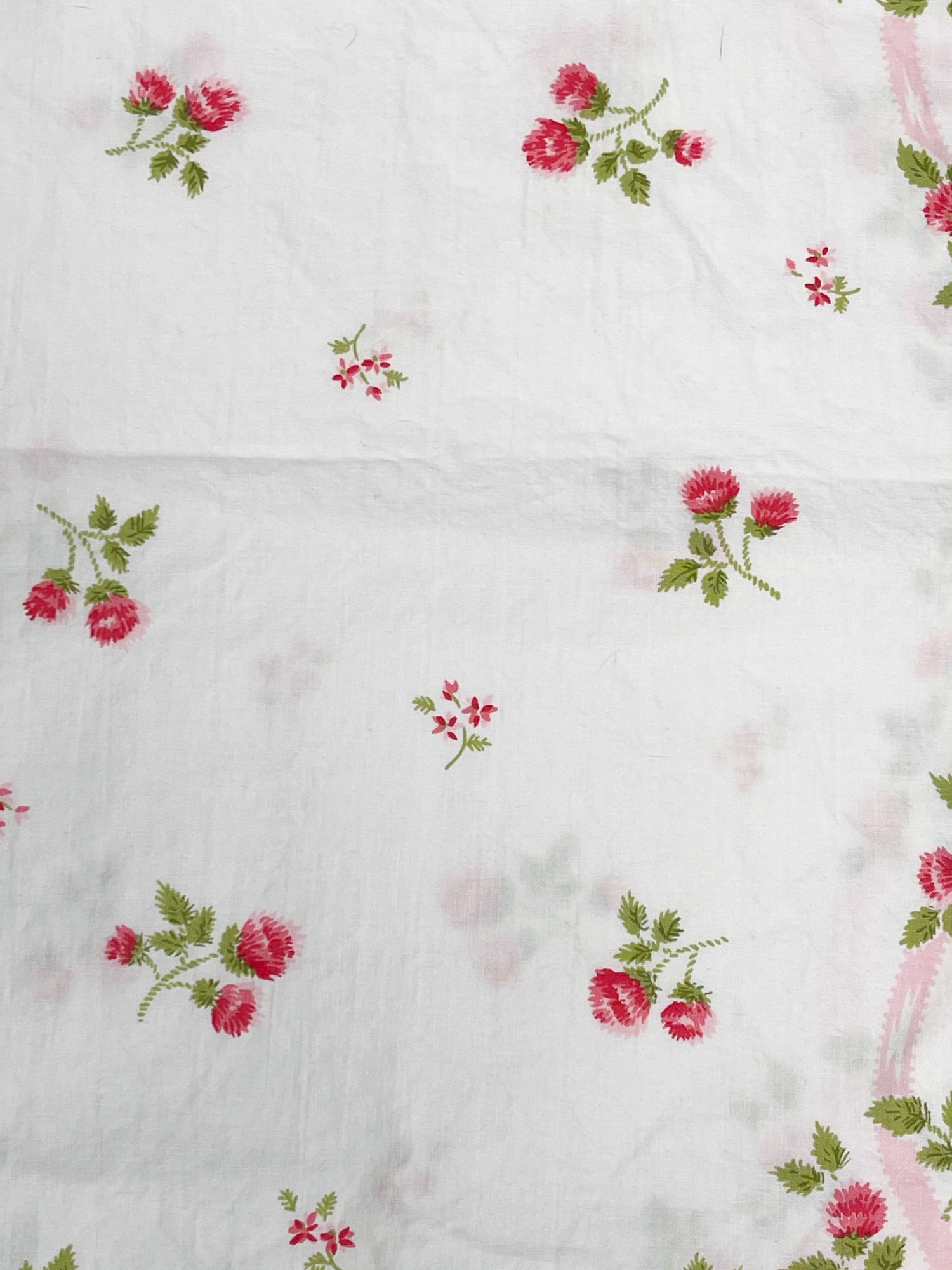 Close-up of center floral design on vintage Springmaid Muslin pillowcase with red wildflowers and greenery