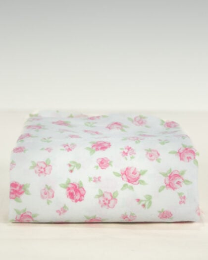 Folded vintage standard pillowcase in white cotton with soft pink ditsy rose floral print