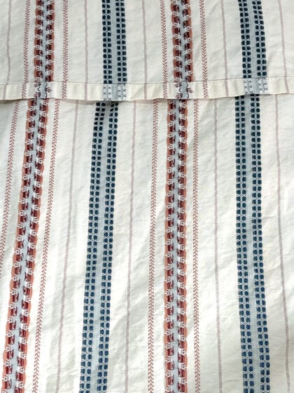 Top-down view of Ralph Lauren Villandry king duvet cover with decorative cream blue and rust striped pattern